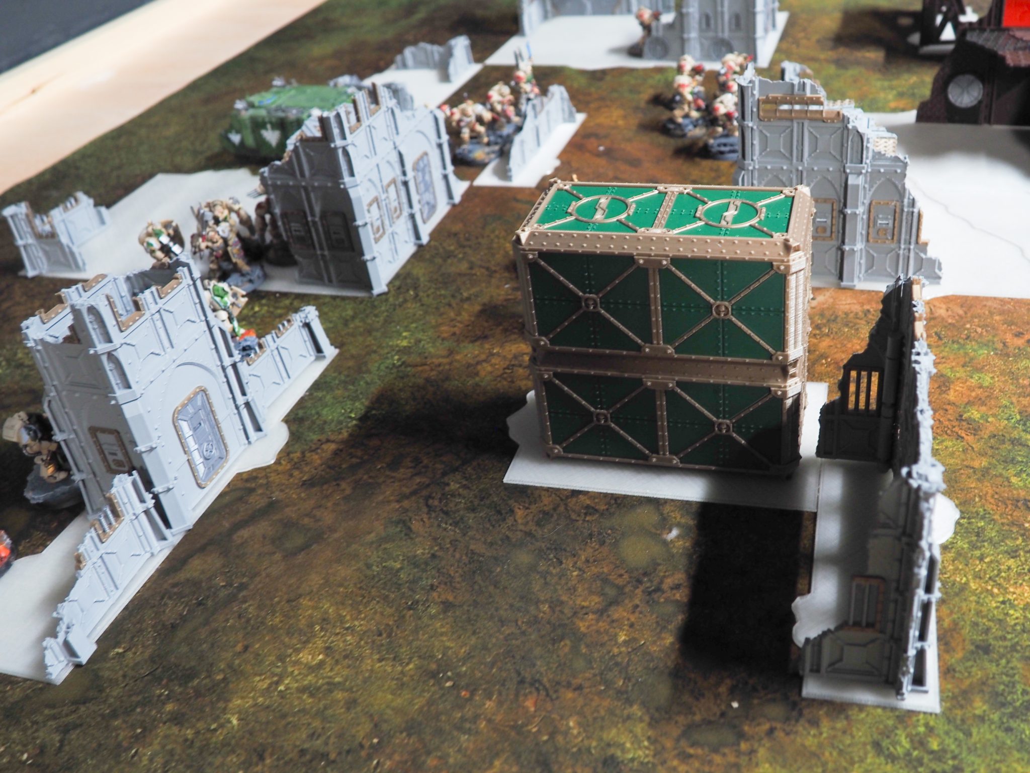 3D-printed tabletop wargaming terrain featuring stacked green shipping containers and grey ruined building walls