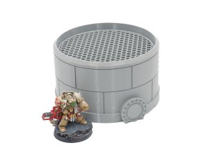 Grey 3D-printed cylindrical storage tank terrain with a grated top, shown next to a tabletop miniature for scale