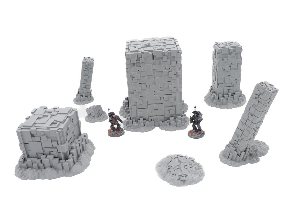 Grey 3D-printed sci-fi terrain set featuring blocky pillars and structures, shown with miniature figures for scale